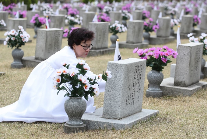 18일 오전 서울 강북구 국립4·19민주묘지에서 이현규씨가 남편 김세중씨의 묘비를 어루만지고 있다. 연합뉴스