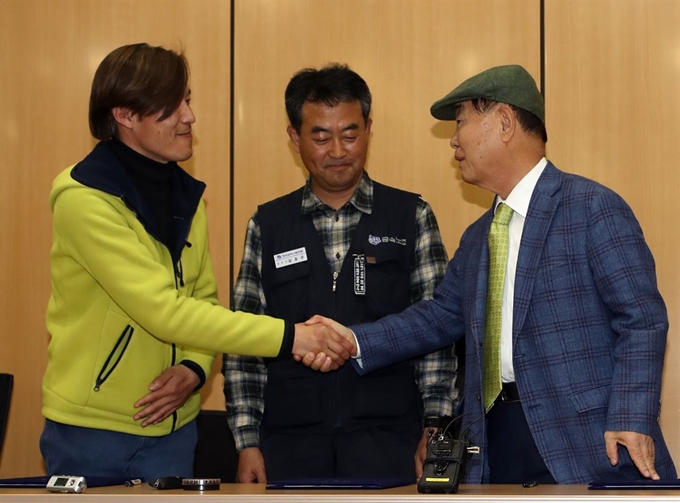 23일 서울 강서구 한국가스공사 서울본부에서 열린 콜텍 노사 조인식에서 이인근(왼쪽) 금속노조 콜텍지회장이 박영호(오른쪽) 콜텍 사장과 노동자 복직 등 내용을 담은 합의안에 서명한 후 악수하고 있다. 연합뉴스