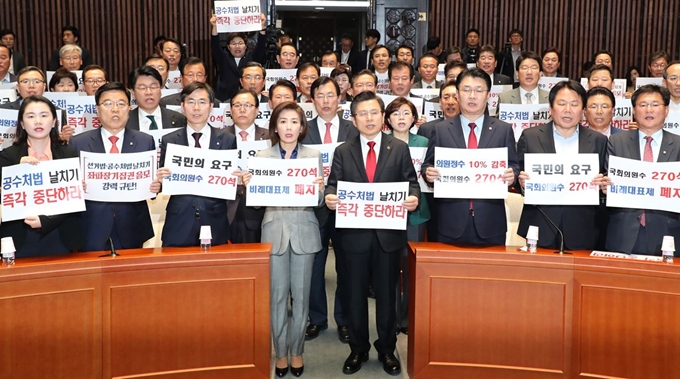 자유한국당 황교안 대표와 나경원 원내대표, 소속 의원들이 23일 오전 국회에서 열린 긴급 의원총회에서 현안 관련 피켓을 들고 구호를 외치고 있다. 연합뉴스.