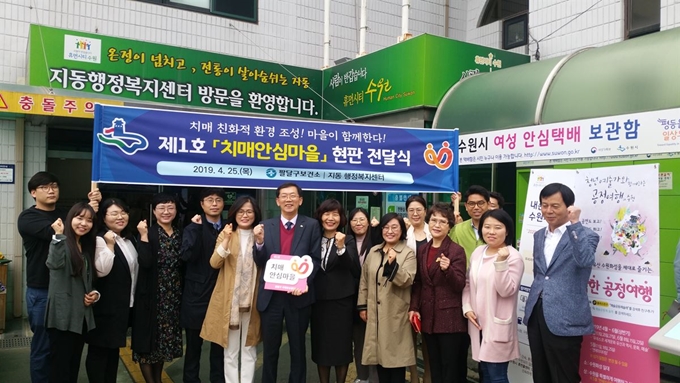 수원시는 25일 수원시 팔달구 지동 내 행정복지센터에서 열린 ‘치매안심마을 1호’ 현판식에 참여한 관계자들이 기념촬영을 하고 있다. 수원시 제공