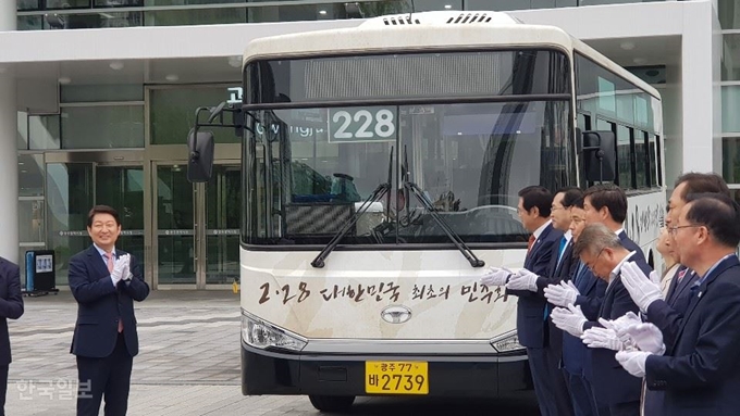 [저작권 한국일보] 권영진(왼쪽) 대구시장이 26일 오전 광주시청 행정동 앞에서 열린 달빛동맹 강화를 위한 ‘228번 시내버스 명명식’에서 이용섭(왼쪽 두 번째) 광주시장 등과 함께 버스 가림막을 걷어낸 뒤 박수를 치고 있다.