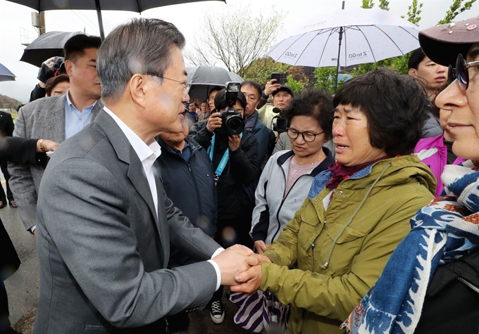 문재인 대통령이 26일 오전 강원도 산불피해 복구현장인 강원도 고성군 토성면을 찾아 복구현장을 살펴본 뒤 이재민들을 위로하고 있다. 연합뉴스