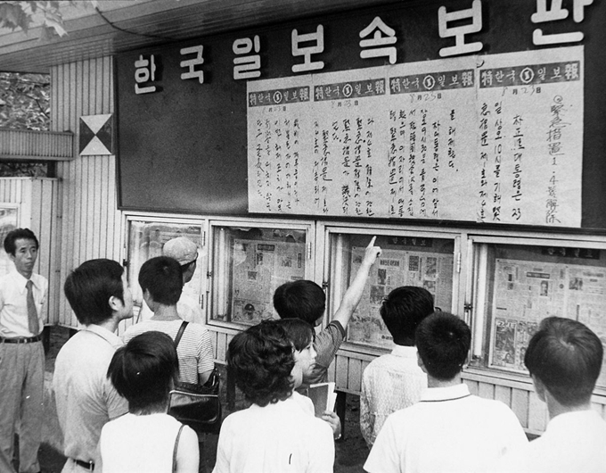 1974년 서울시민들이 한국일보 속보판에 붙어있는 긴급조치 1, 4호 해제 벽보판을 보고 있다. 한국일보 자료사진