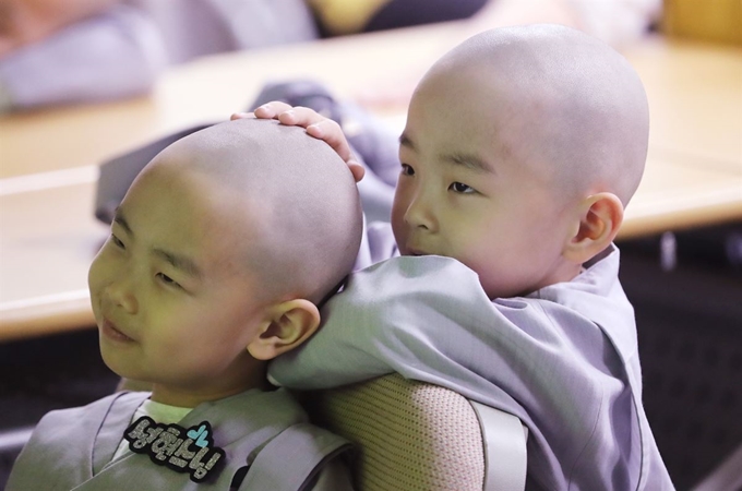 조계사 '단기 출가 보리수 새싹학교' 동자승들이 29일 서울 마포구 동물보호단체 카라에서 열린 유기동물 관리 교실에서 강의를 들으며 앞 사람 머리를 만지고 있다. 연합뉴스