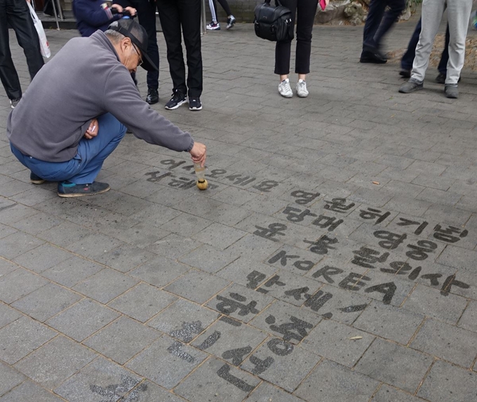 '훙커우 의거' 현장인 중국 상하이 루쉰공원에서 매일 윤봉길 의사를 기리는 한글 문구를 바닥에 쓰는 중국인 자오청셴씨. 연합뉴스