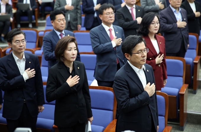 자유한국당 황교안 대표(오른쪽)와 나경원 원내대표(왼쪽 두번째)가 30일 오후 여의도 국회에서 열린 의원총회에서 국민의례를 하고 있다. 연합뉴스.