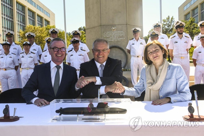 호주의 크리스토퍼 파인(왼쪽부터) 국방장관, 스콧 모리슨 총리와 프랑스의 플로랑스 파를리 국방장관이 11일(현지시간) 호주 캔버라에서 공격용 잠수함 건조 프로젝트에 관한 전략적 동반자 협정에 서명한 후 교차 악수를 하며 미소짓고 있다. 연합뉴스