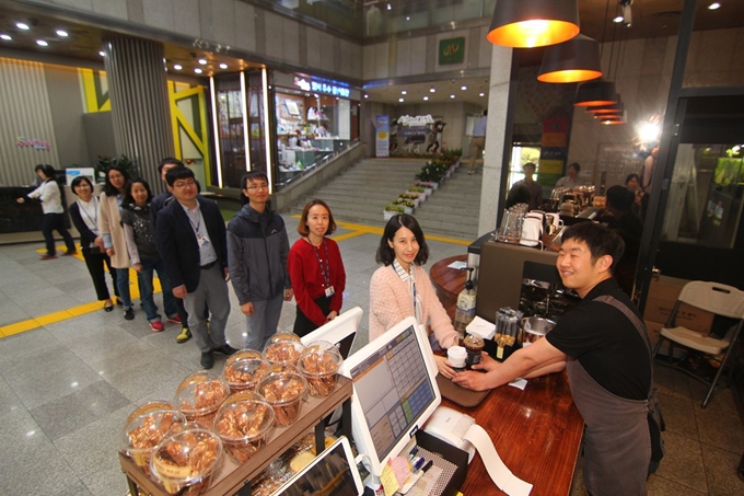 대구 달서구청 직원들이 2일 점심식사 후 구청 1층 로비의 카페 ‘아이 갓 에브리씽’ 앞에 줄을 서서 커피 등 음료수를 주문하고 있다. 장애인 직업재활시설인 학산보호작업장은 2017년 2월부터 달서구청의 위탁을 받아 장애인 등을 고용해 카페를 운영하고 있다. 김민규기자 whitekmg@hankookilbo.com