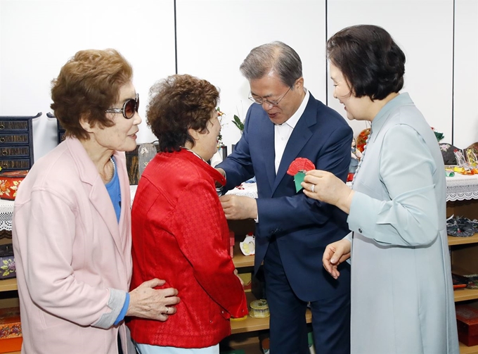 문재인 대통령과 김정숙 여사가 7일 오전 금천구 치매안심센터에서 치매어르신들에게 카네이션을 달아드리고 있다. 연합뉴스