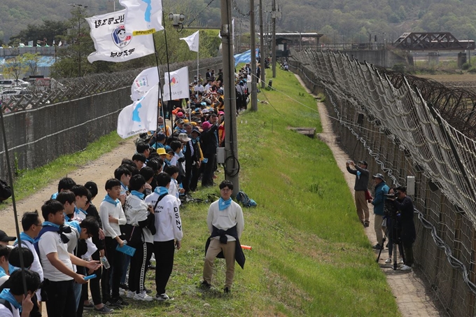 판문점 선언 1주년인 지난달 27일 경기 파주시 임진각 민통선에서 열린 비무장지대(DMZ) 평화손잡기에서 참가자들이 4월 27일을 의미하는 14시 27분을 기다리며 줄지어 있다. 연합뉴스