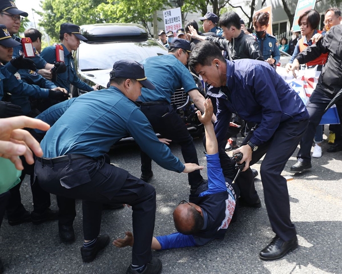 9일 오전 울산시 북구 매곡산업단지 내 한국몰드 앞에서 한 민주노총 조합원이 자유한국당 황교안 대표가 탄 차량 앞에 드러눕자 경찰이 이를 저지하고 있다. 연합뉴스