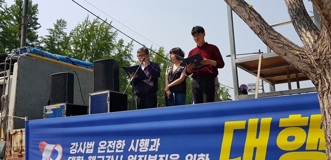 강사법 온전한 시행과 대학 해고강사 원직복직을 위한 대행진 참가자들이 11일 서울 대학로 마로니에 공원에서 결의문을 읽고 있다. 홍인택 기자