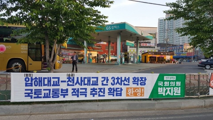 목포 북항도로에 신안 압해대교와 천사대교 간 3차선 확장을 환영하는 현수막이 걸려있다.