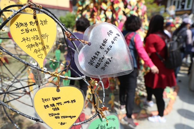 부처님오신날인 12일 오전 대구 팔공산 동화사에서 방문객들이 가족과 지인의 건강과 행복을 바라는 쪽지를 붙이고 있다. 연합뉴스