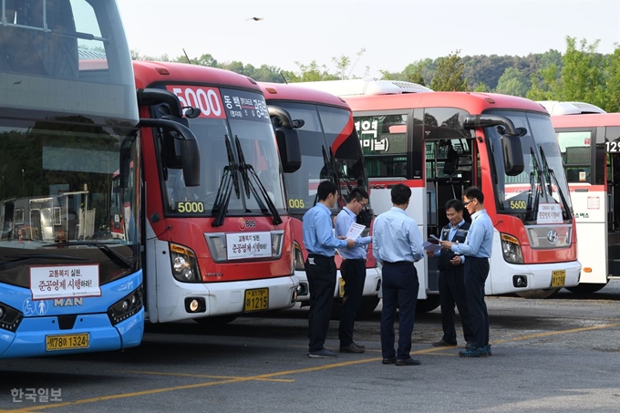 [버스 5] [저작권 한국일보]15일 전국에서 시내버스 파업이 예고된 가운데 지난 14일 경기 용인시 경남여객 차고지에서 기사들이 버스 앞에서 파업관련 대화를 나루고 있다. 배우한 기자.