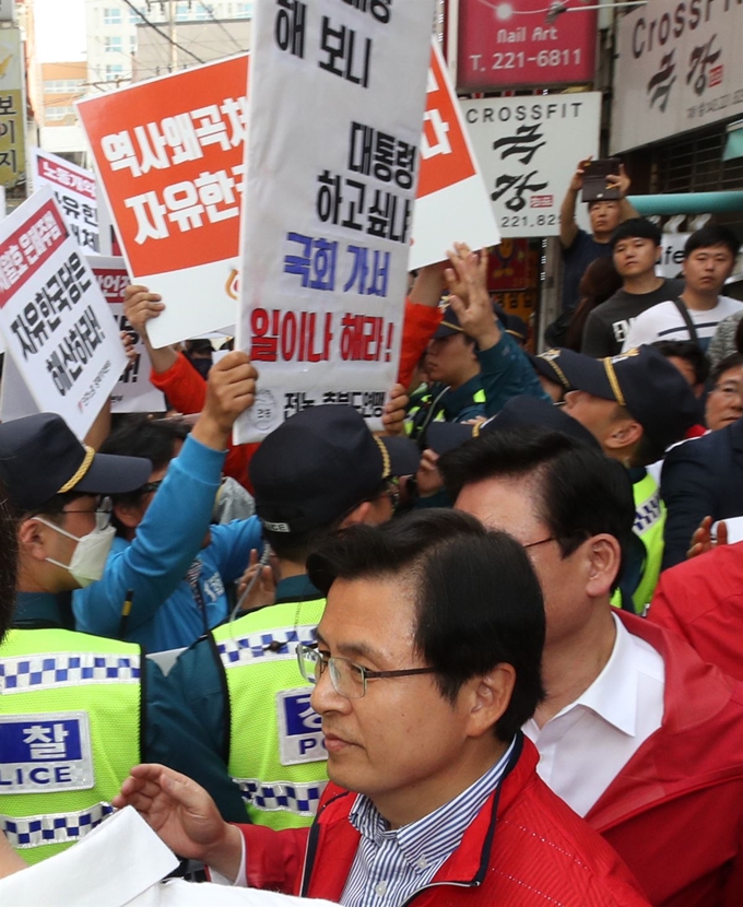 = 자유한국당 황교안 대표가 14일 오후 충북 청주시 상당구 한 커피점에서 학부모 간담회를 마치고 나가던 중 민주노총 충북지역본부 조합원들이 자유한국당 해체를 요구하며 시위를 벌이자 경찰의 도움을 받아 빠져나가고 있다. 연합뉴스