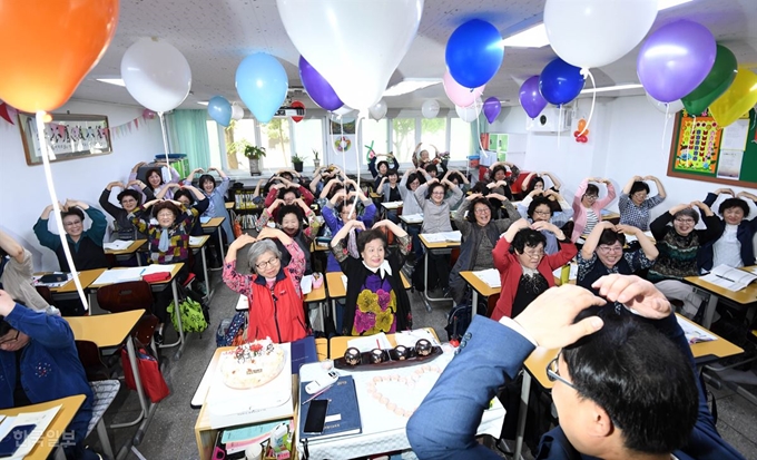 스승의 날인 15일 서울 마포구 일성여자중고등학교에서 만학도 할머니들이 손을 머리 위로 올려 선생님에게 하트를 그리고 있다. 서재훈 기자