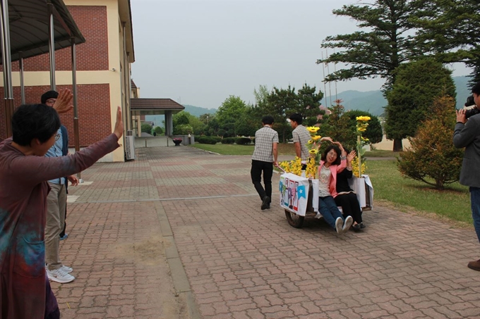 청주 미원중학교 학생들이 15일 리어카로 만든 꽃마차에 선생님을 태워 교무실로 향하고 있다. 미원중학교 제공