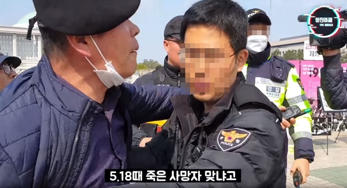 지난 3월 서울 여의도 국회 앞에서 5ㆍ18 당시 피해사진을 전시하며 농성 중이던 5ㆍ18피해자들을 찾아간 채널 ‘상진아재’ 운영자 유튜버 김상진씨가 “이 사진 피해자가 5ㆍ18 때 죽은 사람 맞냐"고 묻다 제지강하고 있다. 유튜브 캡처