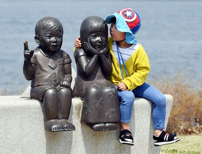 한 아이가 여의도 한강시민공원에 설치된 동상에 다가가 친밀감을 표현하고 있다.