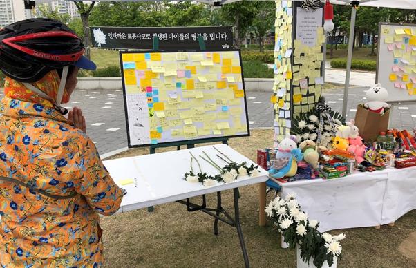 17일 오전 인천 연수구 송도국제도시 송도캠퍼스타운 아파트단지 앞 사거리 인근 잔디밭에 조성된 축구교실 차량사고 초등학생 희생자 2명을 추모하는 공간에서 한 시민이 기도를 하고 있다.