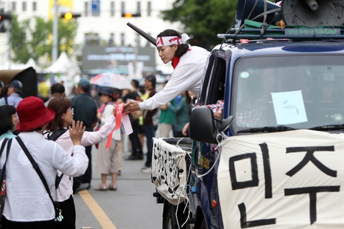 17일 광주 동구 금남로 옛 전남도청 앞에서 5·18 민주화운동 당시 가두방송 재연에 나선 시민이 이날 저녁 열리는 '5·18 39주년 전야제' 참여를 독려하고 있다. 연합뉴스