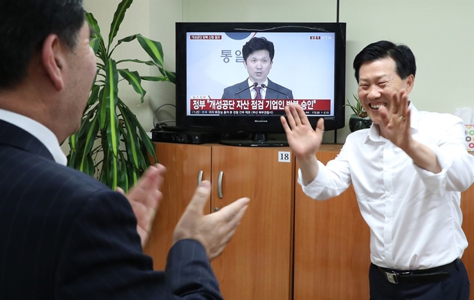 17일 오후 서울 여의도에 있는 개성공단 기업협회에서 유창근 개성공단기업협회 부회장(왼쪽)과 김서진 상무가 개성공단 기업인 방북승인 문제와 관련한 통일부 브리핑을 시청하며 환호하고 있다. 연합뉴스