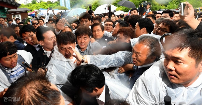 [망15] [저작권 한국일보]황교안 5·18기념식 참석 길 '혼란'18일 오전 광주 북구 국립 5·18민주묘지에서 열린 '제39주년 5·18민주화운동 기념식'에 참석한 자유한국당 황교안 대표가 '망언 의원' 징계 등을 요구하는 시민의 항의에 일행, 경찰과 뒤엉켜 이동하고 있다. 광주= 서재훈 기자 spring@hankookilbo.com /2019-05-18(한국일보)