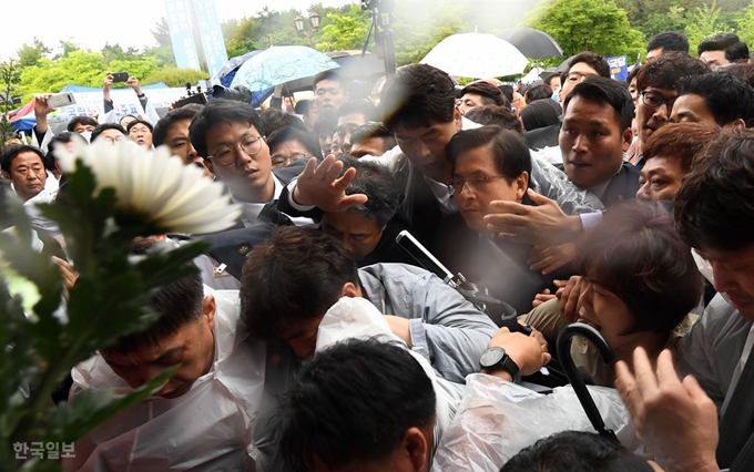 [망12] [저작권 한국일보]황교안 5·18기념식 참석 길 '혼란'18일 오전 광주 북구 국립 5·18민주묘지에서 열린 '제39주년 5·18민주화운동 기념식'에 참석한 자유한국당 황교안 대표가 민주의문으로 들어서자 '망언 의원' 징계 등을 요구하는 시민들이 국화를 던지며 항의하고 있다. 광주= 서재훈 기자 spring@hankookilbo.com /2019-05-18(한국일보)