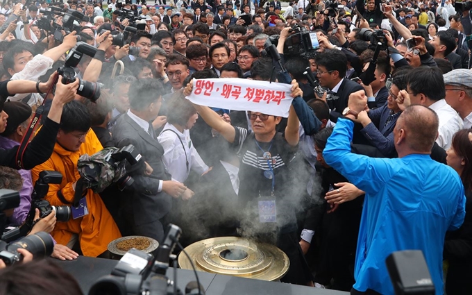 황교안 자유한국당 대표가 18일 오전 제39주년 5ㆍ18 민주화운동 기념식이 열린 광주 국립5ㆍ18민주묘지에서 시민들의 항의에 분향을 못 하고 있다. 연합뉴스.