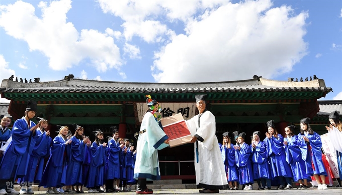 20일 성균관대학교 명륜당에서 성균관대 교양필수과목 중 하나인 '성균 논어' 중간고사 응시자 중 급제자로 선발된 33명의 학생들이 채점관, 선배, 친족을 방문하는 '유가행렬'를 재현하며 홍패를 펼쳐보이고 있다.배우한 기자