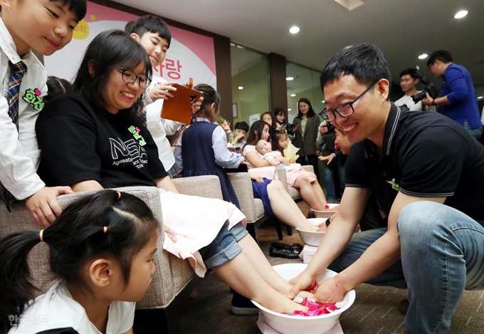 21일 오전 서울 강남구 역삼동 듀오 본사에서 부부의 날을 맞아 다둥이 가족 세족식 행사가 열린 가운데 남편이 아내의 발을 정성스럽게 닦아주고 있다. 홍인기 기자