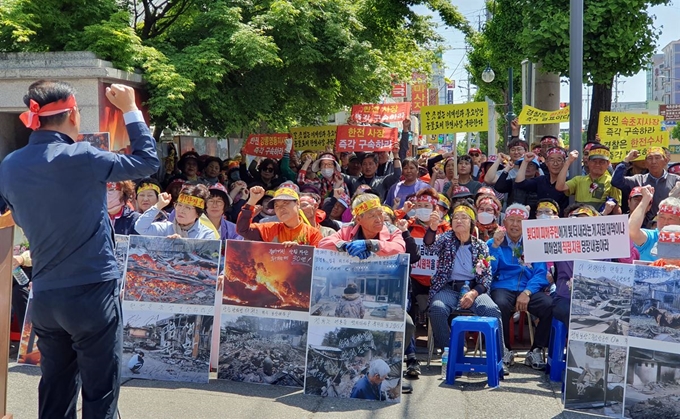 8일 한국전력공사 속초지사 앞에서 열린 산불피해 보상촉구 집회에 참여한 이재민들이 한전의 적극적인 피해보상을 촉구하는 구호를 외치고 있다.