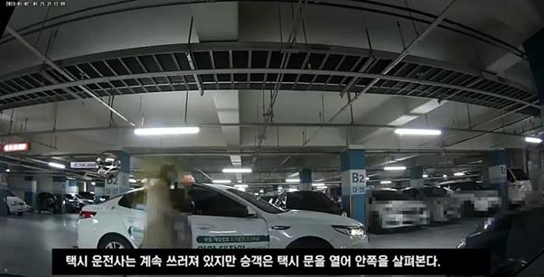 지난해 12월 8일 오전 인천 남동구 한 아파트단지 지하주차장에서 30대 승객이 자신과 다투던 택시기사가 쓰러진 상황에서 택시 문을 열어 안쪽을 살펴보고 있다. 동영상 캡처