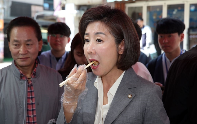 자유한국당 나경원 원내대표가 22일 서울 관악구 신림동 일대에서 소상공인특위·소폐경활특위 소상공인 현장간담회에 앞서 지역 상인들의 애로사항을 듣고 만두를 사 먹고 있다. 연합뉴스