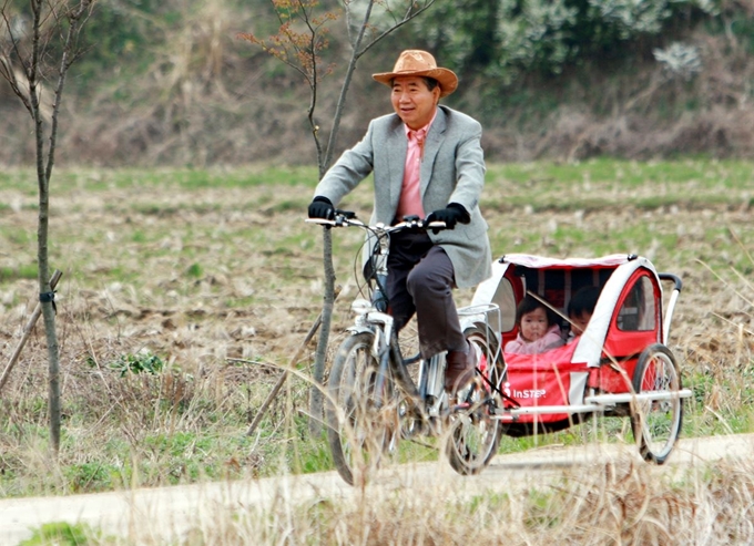 퇴임 후 경남 김해시 봉하마을로 내려온 고(故) 노무현 전 대통령이 2008년 4월 자전거 뒤 수레에 손녀를 태우고 마을 주변을 달리고 있다. 사람사는세상 노무현재단 제공