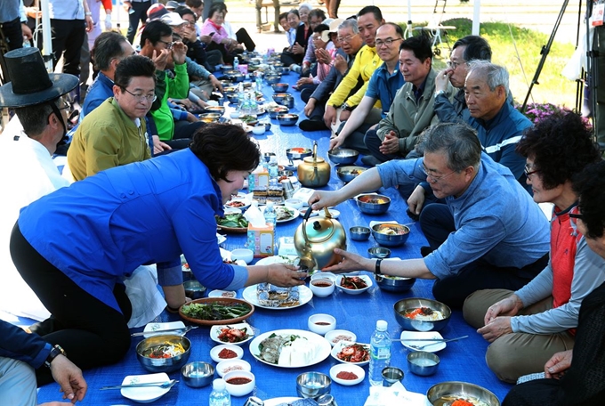 문재인 대통령이 24일 경북 경주시 옥산마을에서 모내기를 한뒤 마을 주민과 새참을 하고 있다. 경주=류효진 기자