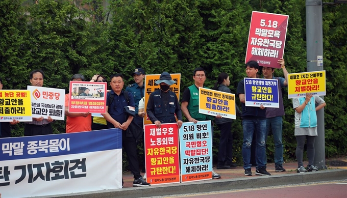 24일 오전 경기도 수원 영통구 광교센트럴타운 60단지 앞에서 민주노총과 민중당 관계자들이 아파트 주민들과 간담회를 위해 방문 예정인 자유한국당 황교안 대표를 규탄하는 손팻말을 들고 있다. 연합뉴스