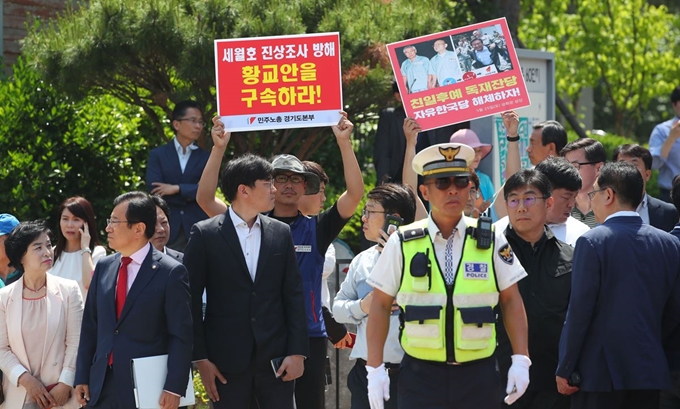 24일 오전 경기도 수원 영통구 광교센트럴타운 60단지 앞에서 민주노총과 민중당 관계자들이 아파트 주민들과 간담회를 위해 방문 예정인 자유한국당 황교안 대표를 규탄하는 손팻말을 들고 있다. 연합뉴스