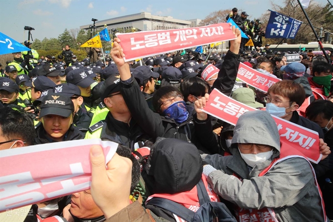 지난달 3일 국회 정문 앞에서 열린 집회에서 민주노총 노조원들이 노동법 개악 저지 등을 주장하며 담장을 부수고 국회 경내 진입을 시도하고 있다. 오대근 기자