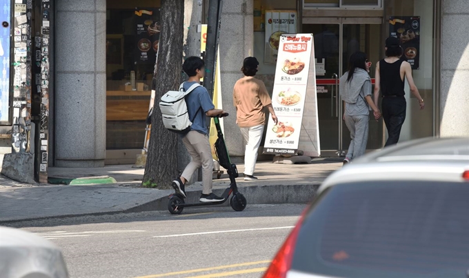 공유 전동킥보드를 탄 남성이 24일 서울 마포구 홍대 앞 차로 위를 역주행하고 있다. 법규 위반으로 인한 사고 시 불이익을 받을 수 있는 만큼 이용자의 주의가 필요하다.