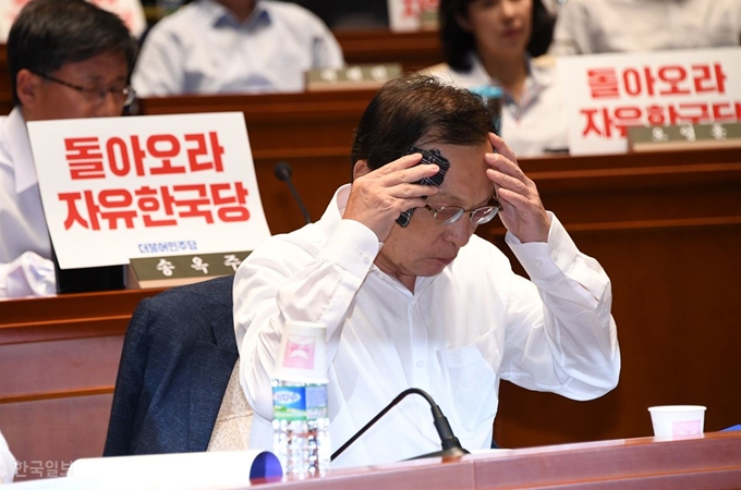 이해찬 대표가 국회에서 열린 국회의원 워크숍에 참석해 자유한국당을 향해 국회 정상화를 촉구하는 피켓팅을 한 후 손수건으로 얼굴을 닦고 있다. 오대근기자