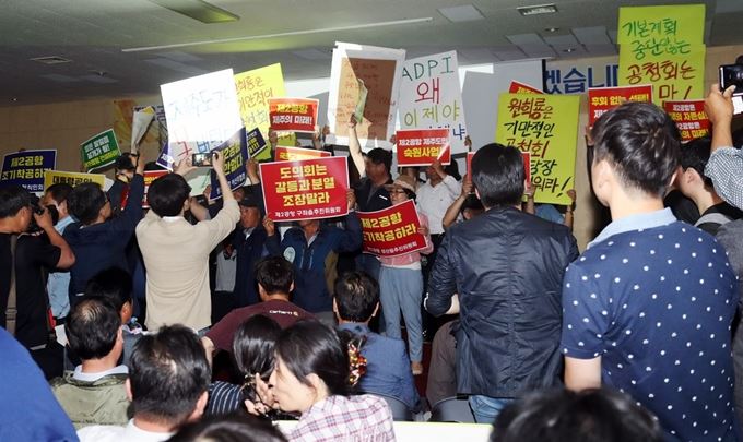 지난 23일 오후 제주시 오라1동 제주종합경기장 제주도체육회관에서 열린 제2공항 기본계획 반영 과제 발굴 1차 공청회에서 제2공항 찬성과 반대단체 회원들이 손팻말을 들고 있다. 연합뉴스.