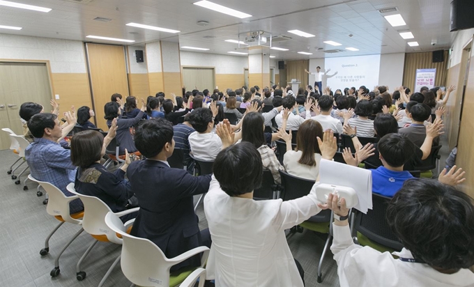 5월 25일 부산 북구 금곡동 금곡도서관에서 열린 '10월의 하늘' 10주년 기념 강연에서 뇌 과학자 장동선 박사가 강의하고 있다. 청중들이 장동선 박사의 지휘에 맞춰 '거울동작'을 하고 있다. 부산 북구청 제공