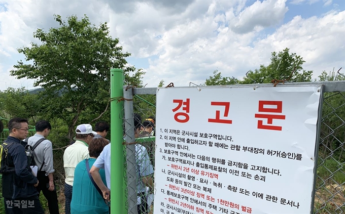 DMZ 평화의 길 사전 탐방 행사 참가자들이 경고문이 적힌 민통선을 통과하고 있다.