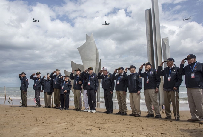 1944년 6월 6일 미,영,프랑스, 호주 등 8개국 연합군이 당시 독일이 점령하고 있던 프랑스 북부 노르망디 해안에서 감행한 지상최대 작전인 '노르망디 상륙작전(D-Day)' 75주년을 앞두고 3일(현지시간) 프랑스 노르망디 오마하 비치를 방문한 미국에서 온 2차대전 참전용사들이 '더 브레이브' 기념비 앞에서 경레를 하며 포즈를 취하고 있다. AP 연합뉴스