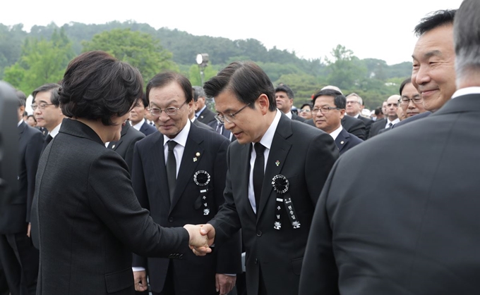 김정숙 여사가 6일 오전 국립서울현충원에서 제64회 현충일 추념식에 참석한 자유한국당 황교안 대표와 악수하고 있다. 연합뉴스