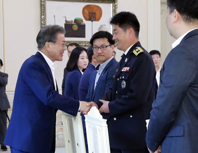 문재인 대통령이 7일 낮 청와대에서 열린 '국민께 힘이 되는 일 잘하는 공무원' 초청 오찬에 입장하며 강원도 산불 진화에 기여한 박정훈 소방청 소방경과 인사하고 있다. 연합뉴스