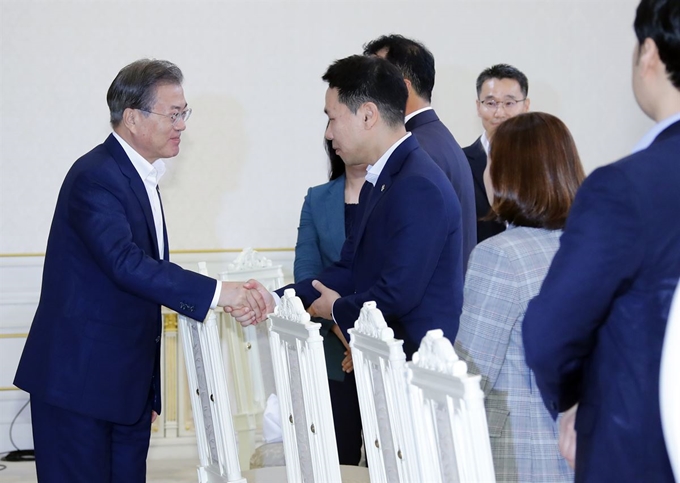 문재인 대통령이 7일 낮 청와대에서 열린 '국민께 힘이 되는 일 잘하는 공무원' 초청 오찬에 입장하며 인도네시아 잠수함 수출에 기여한 이상우 방위사업청 센터장과 인사하고 있다. 연합뉴스