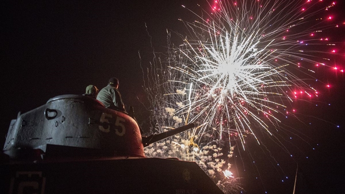 1944년 6월 6일 미,영,프랑스, 호주 등 8개국 연합군이 당시 독일이 점령하고 있던 프랑스 북부 노르망디 해안에서 감행한 지상최대 작전인 '노르망디 상륙작전(D-Day)' 75주년을 맞은 6일(현지시간) 프랑스 노르망디 아로망슈레뱅에서 시민들이 탱크 위에 앉아 불꽃놀이를 바라보고 있다. AP 연합뉴스